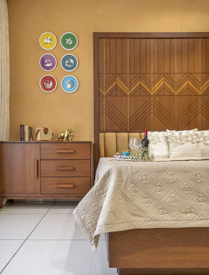 Luxurious modern bedroom interior design by Olangana Design in Bangalore featuring a wooden headboard, beige bedding, and decorative wall art for a sophisticated living space.