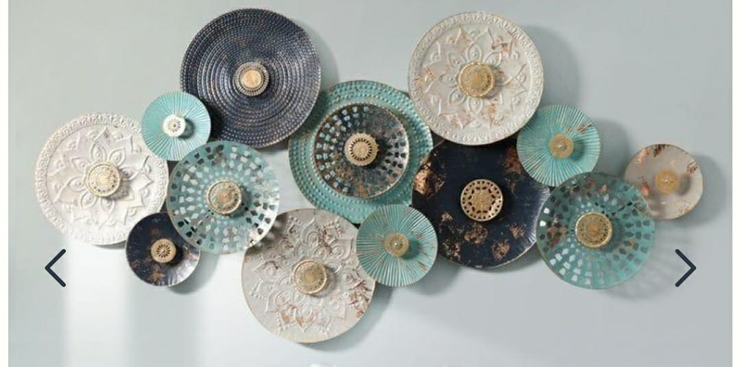 Boho chic metal wall art featuring various textured blue, white, and gold decorative plates, enhancing a modern interior by Olangana Design in Bangalore.