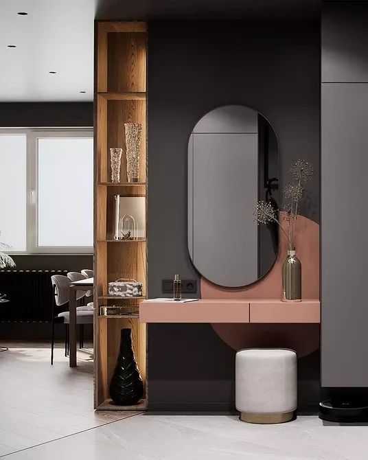 Modern interior design by Olangana Design in Bangalore, featuring a stylish pink vanity with an oval mirror, a white stool, and a tall wooden display shelf with decor.