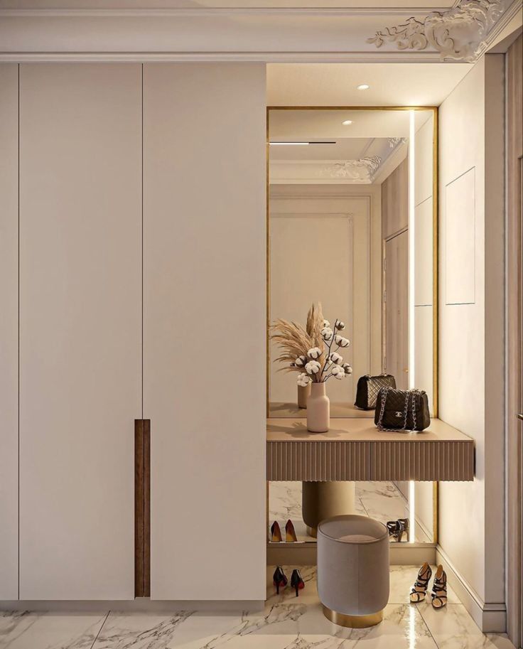 Modern luxury dressing area with integrated wardrobe and vanity, designed by Olangana Design. Elegant interior styling with gold accents and marble flooring in Bangalore.