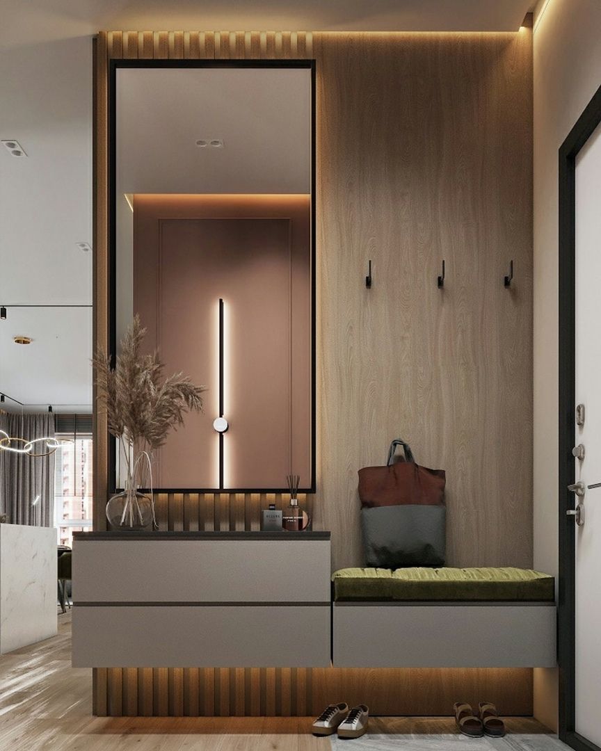 Modern entryway interior design by Olangana Design in Bangalore featuring a full-length mirror, integrated console with storage, wooden slat paneling with hooks, and a built-in seating bench with ambient lighting.