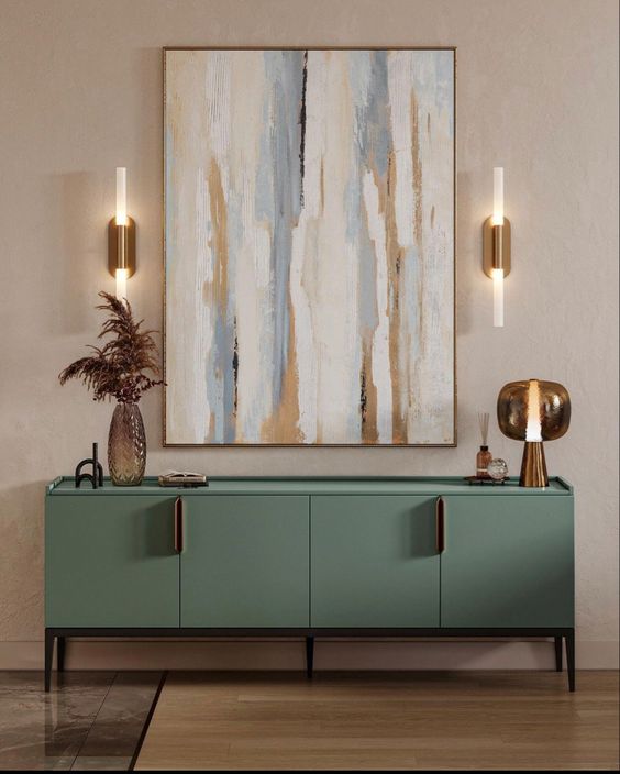 Modern living room interior with sage green sideboard, abstract art, and contemporary wall sconces by Olangana Design in Bangalore.