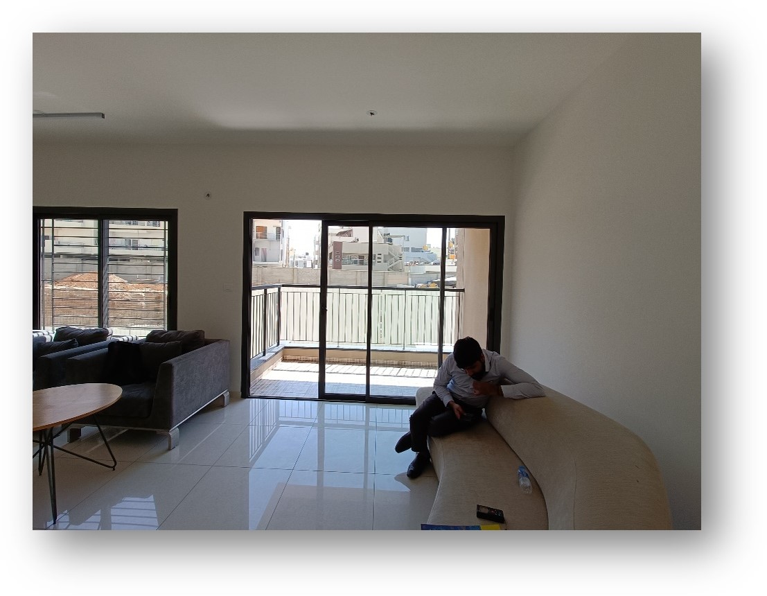 Spacious living room site in Bangalore, featuring large windows and initial modern furniture, ready for a stunning interior design transformation by Olangana Design.