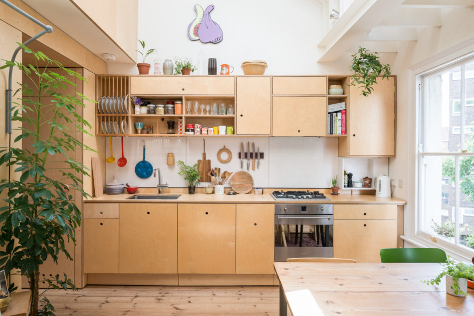 Modern plywood kitchen interior design by Olangana in Bangalore, featuring light wood cabinetry, open shelving, integrated appliances, and vibrant kitchenware.