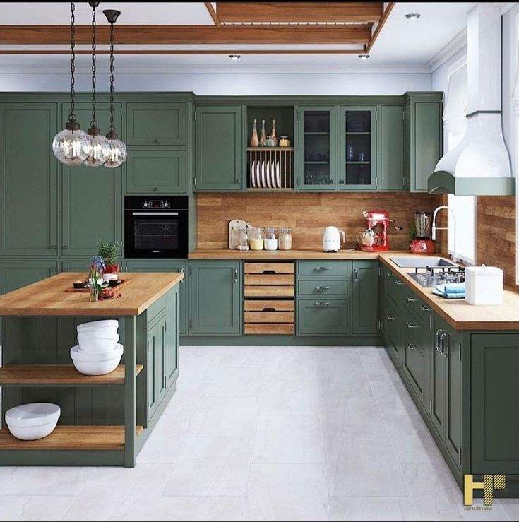 Elegant sage green kitchen interior design by Olangana in Bangalore, featuring shaker-style cabinets, warm wood countertops, a central island with open shelving, and modern pendant lighting.