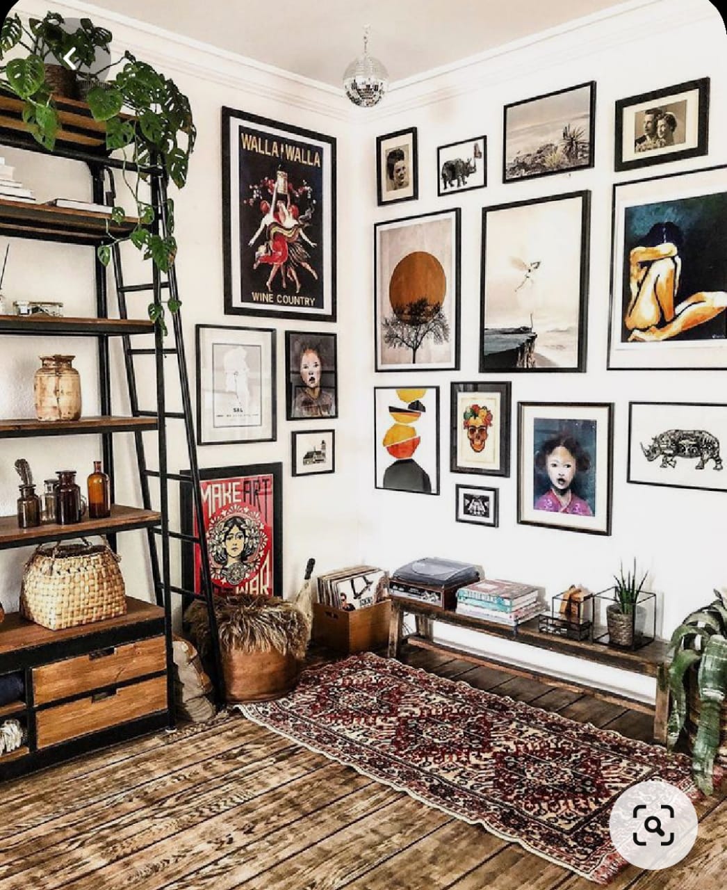 Eclectic bohemian living room interior design by Olangana in Bangalore, featuring a vibrant gallery wall, industrial-style shelving, a patterned rug, and a whimsical disco ball.