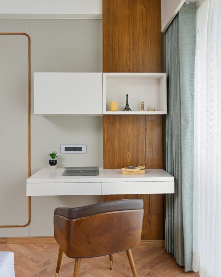 Modern home office Interior Design featuring a floating white desk, elegant wooden paneling, and a stylish wooden chair with a leather seat, expertly crafted by Olangana Design in Bangalore. This space showcases efficient and sophisticated Interior Design.