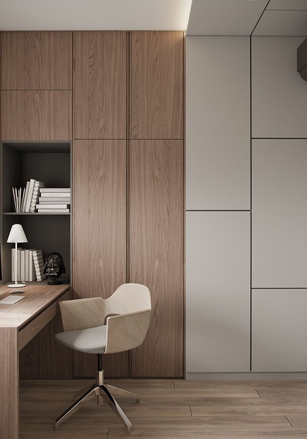 A sophisticated home office interior design by Olangana in Bangalore, featuring sleek wooden cabinetry, an integrated desk, and a modern light wood and grey swivel chair. The minimalist aesthetic with warm wood tones and muted grey panels creates a productive and elegant workspace.