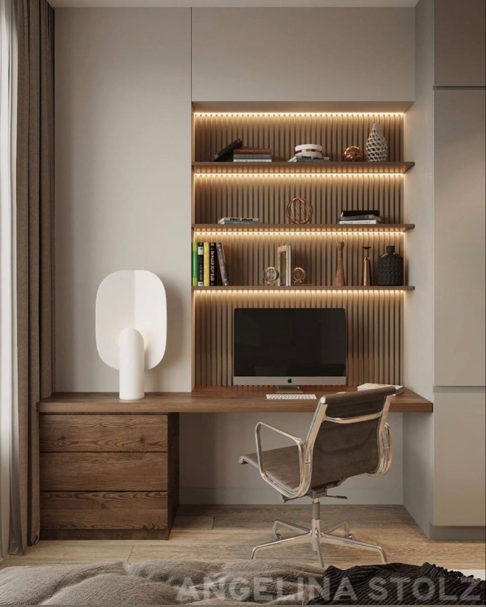 A sophisticated modern home office interior design by Olangana, featuring a sleek floating wooden desk, integrated shelving with warm LED strip lighting, and a contemporary ergonomic chair. This functional and elegant workspace is a prime example of premium Interior Design in Bangalore.