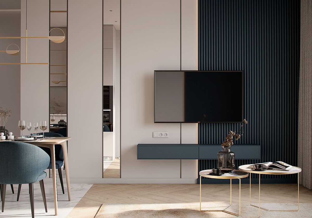 A sophisticated modern living and dining area with a deep navy ribbed accent wall, sleek floating TV console, and gold nesting coffee tables. This elegant Interior Design by Olangana showcases contemporary style in Bangalore.