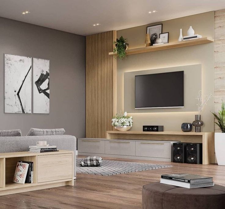 Elegant living room Interior Design by Olangana in Bangalore, featuring a modern media wall with warm backlighting, a sleek light wood and grey console, and sophisticated neutral tones alongside striking black and white abstract art.