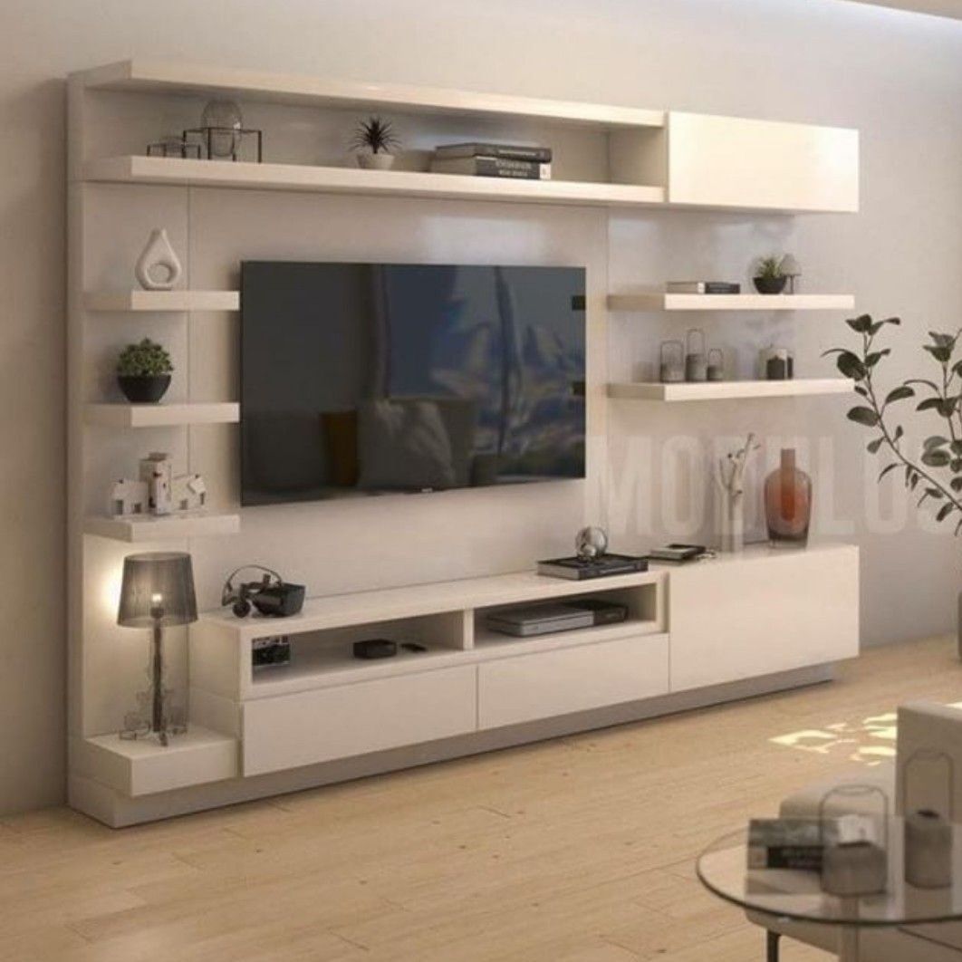A modern white wall-mounted TV unit featuring multiple floating shelves, integrated ambient lighting, and elegant decorative accents, showcasing Olangana's exceptional Interior Design in Bangalore.
