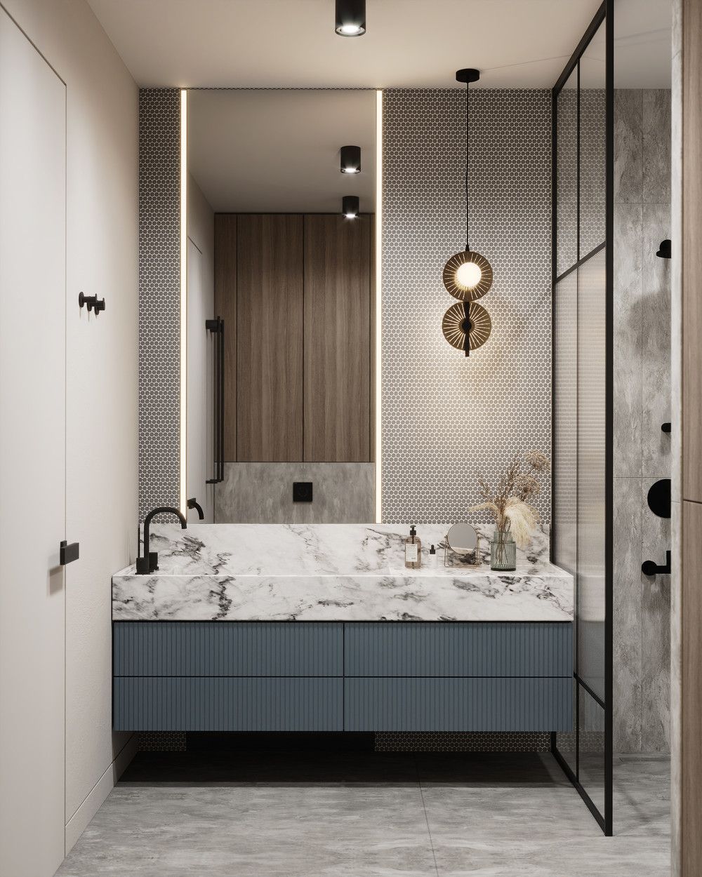 A luxurious modern bathroom interior design by Olangana in Bangalore, showcasing a white marble vanity with elegant dark blue ribbed cabinets, a large illuminated mirror, and a sophisticated round pendant light. This space exemplifies premier Interior Design.