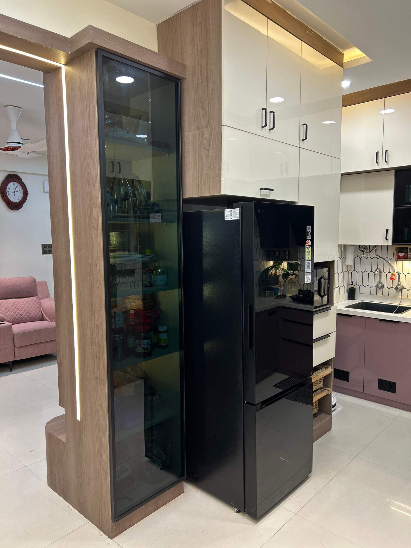 Modern modular kitchen with tall pantry cabinet and refrigerator space.
