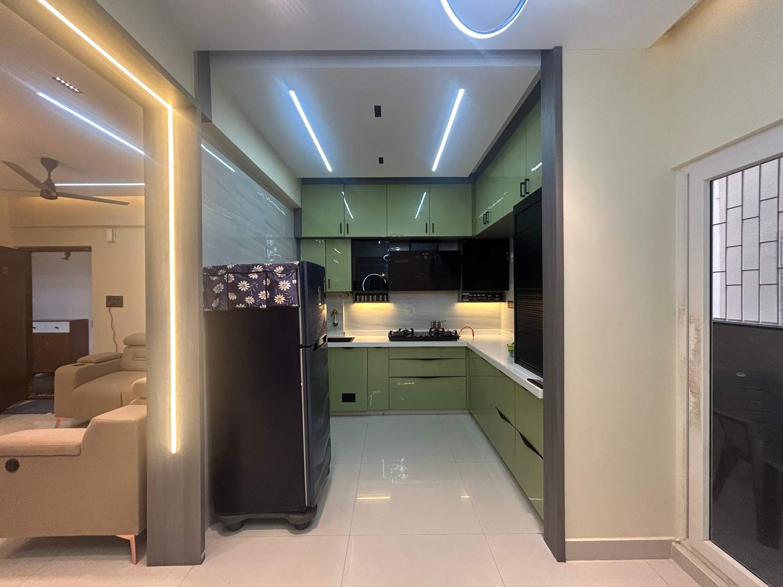 Modern green modular kitchen with rolling shutter cabinet in Bangalore by Olangana Design’s.