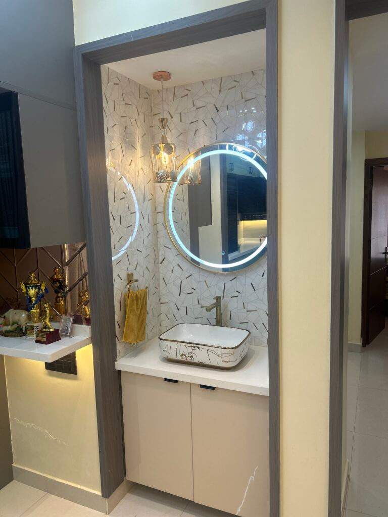 Dining space wash basin unit with closed shelf racks in Bangalore home by Olangana Design’s.