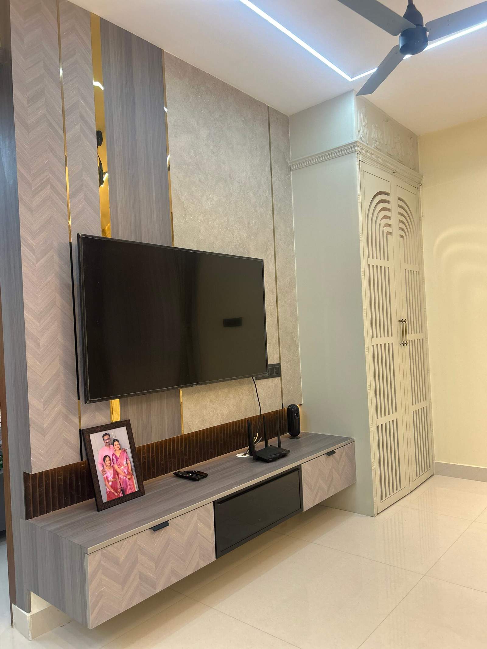Compact pooja room with enclosed doors in living room near TV cabinet in Bangalore home by Olangana Design’s.