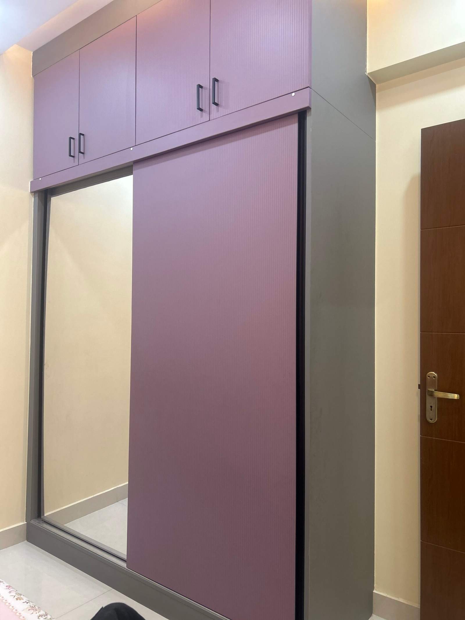 Modern dressing room interior with wall-mounted mirror in a Bangalore home by Olangana Design’s.