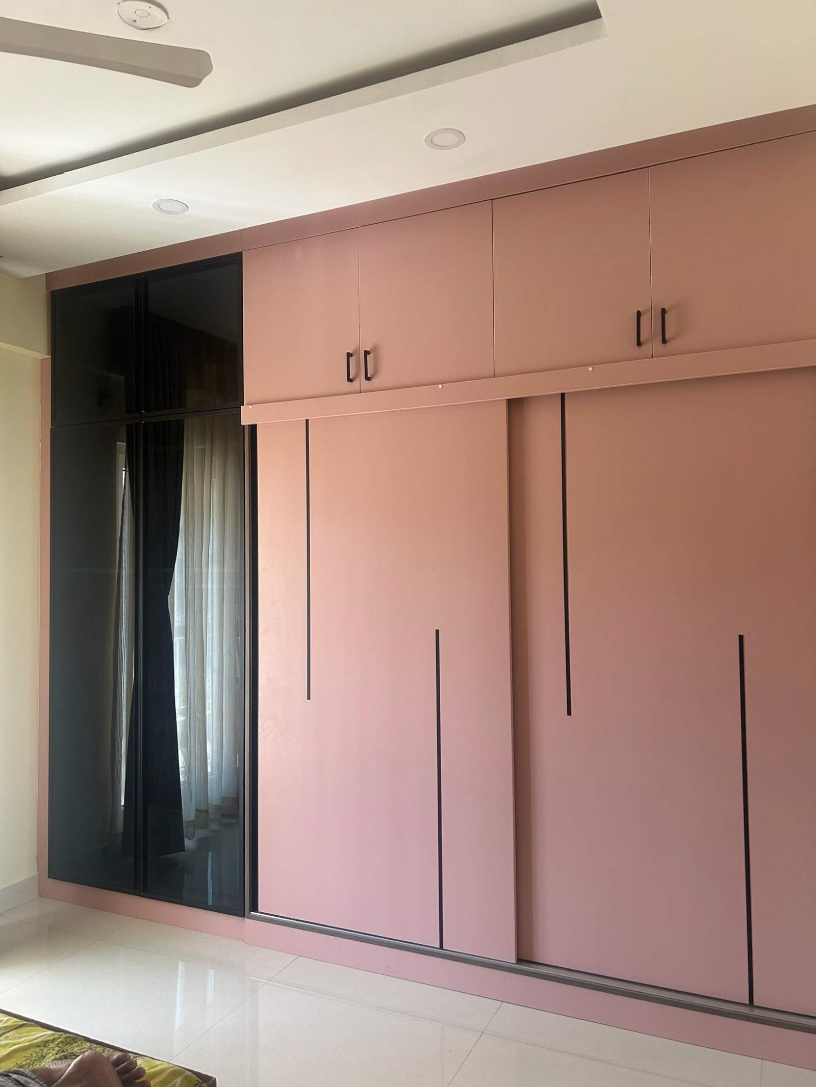 Elegant modular bedroom with sliding wardrobe panels, dressing mirror wall, and space-saving ironing table by Olangana Design’s.