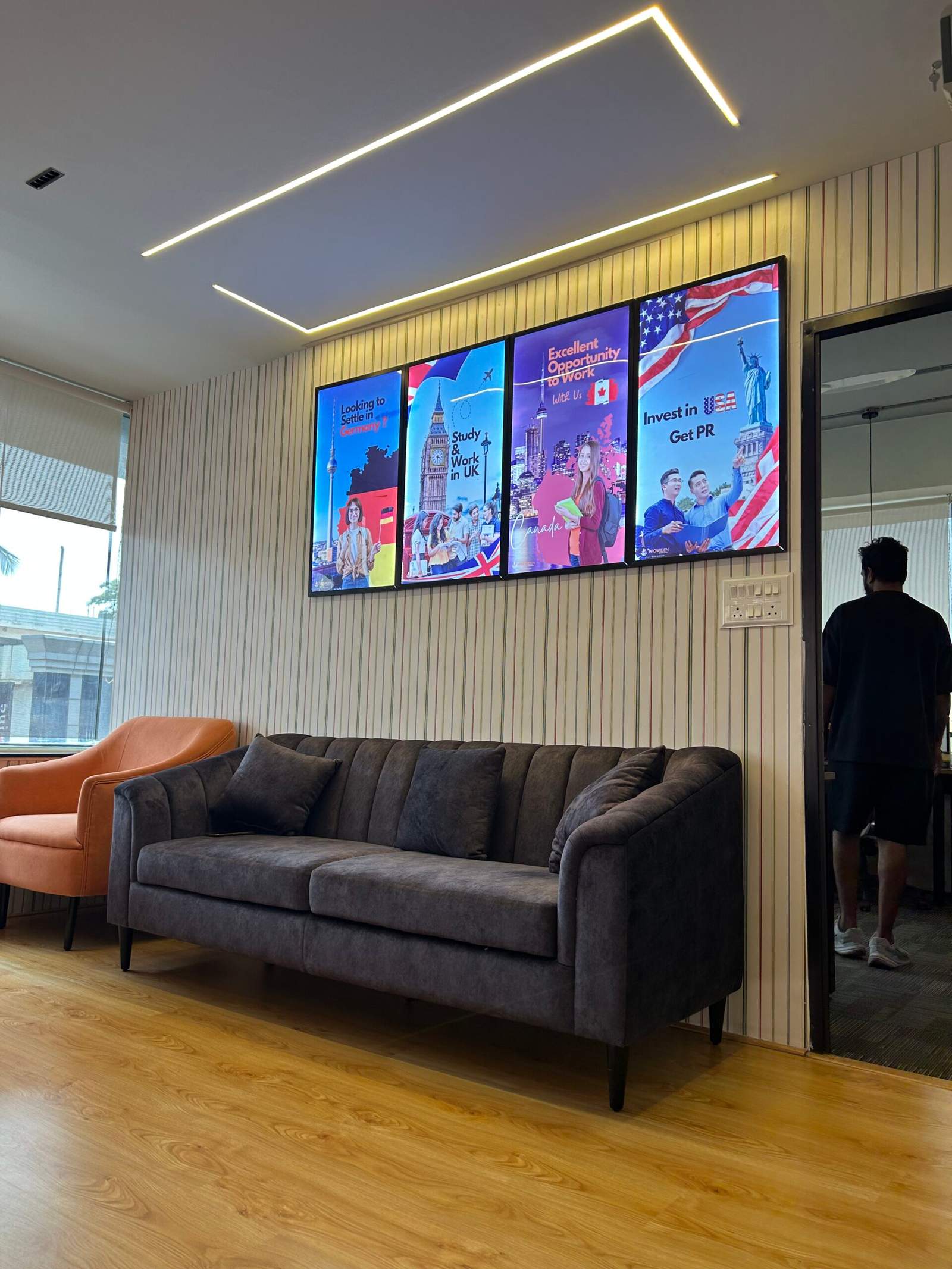 Office conversation seating area in Bangalore with two sofas facing each other and three wall art frames by Olangana Designs