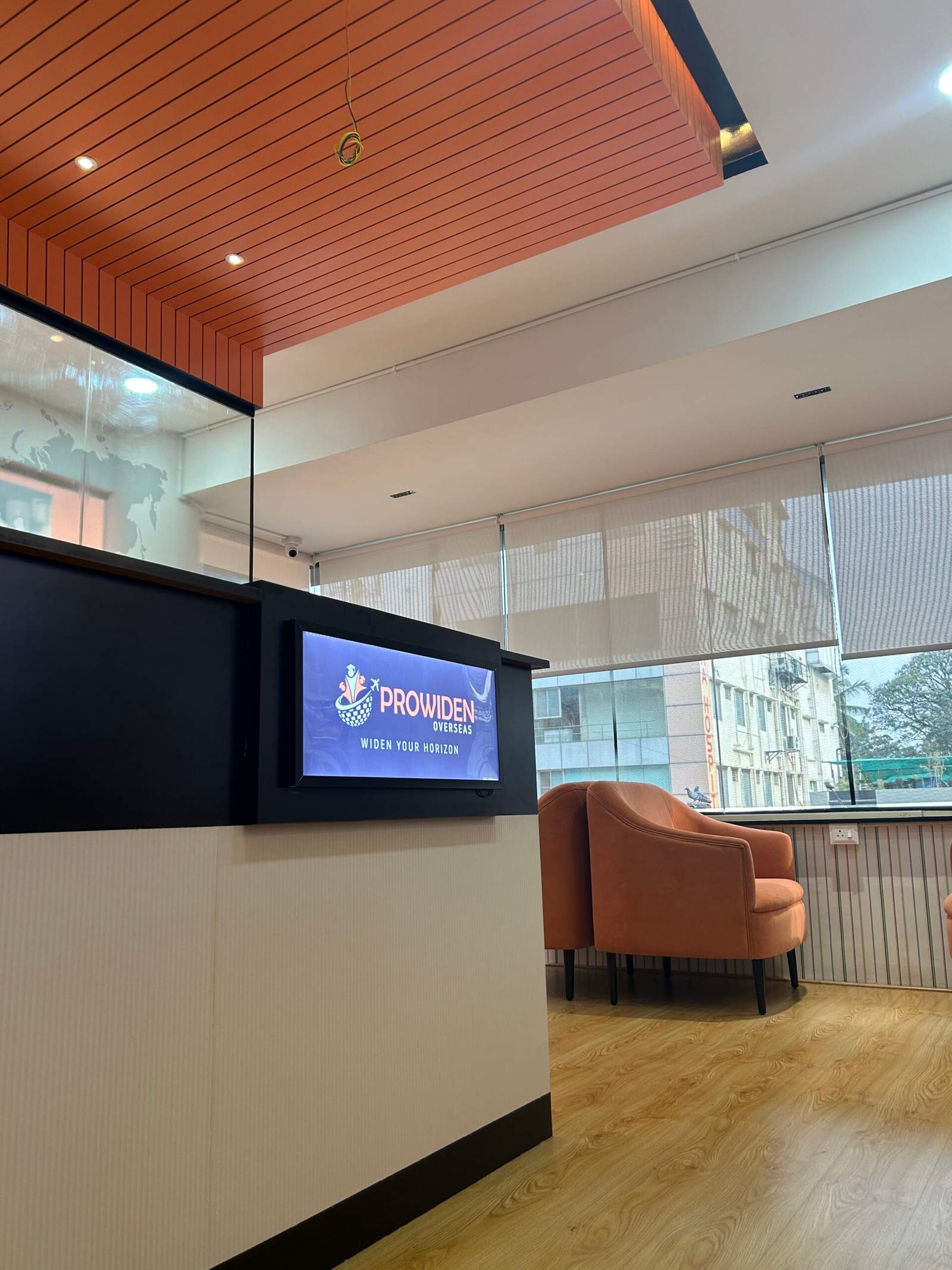 Modern office lounge in Bangalore with opposite sofa seating near window for relaxed discussion area by Olangana Designs