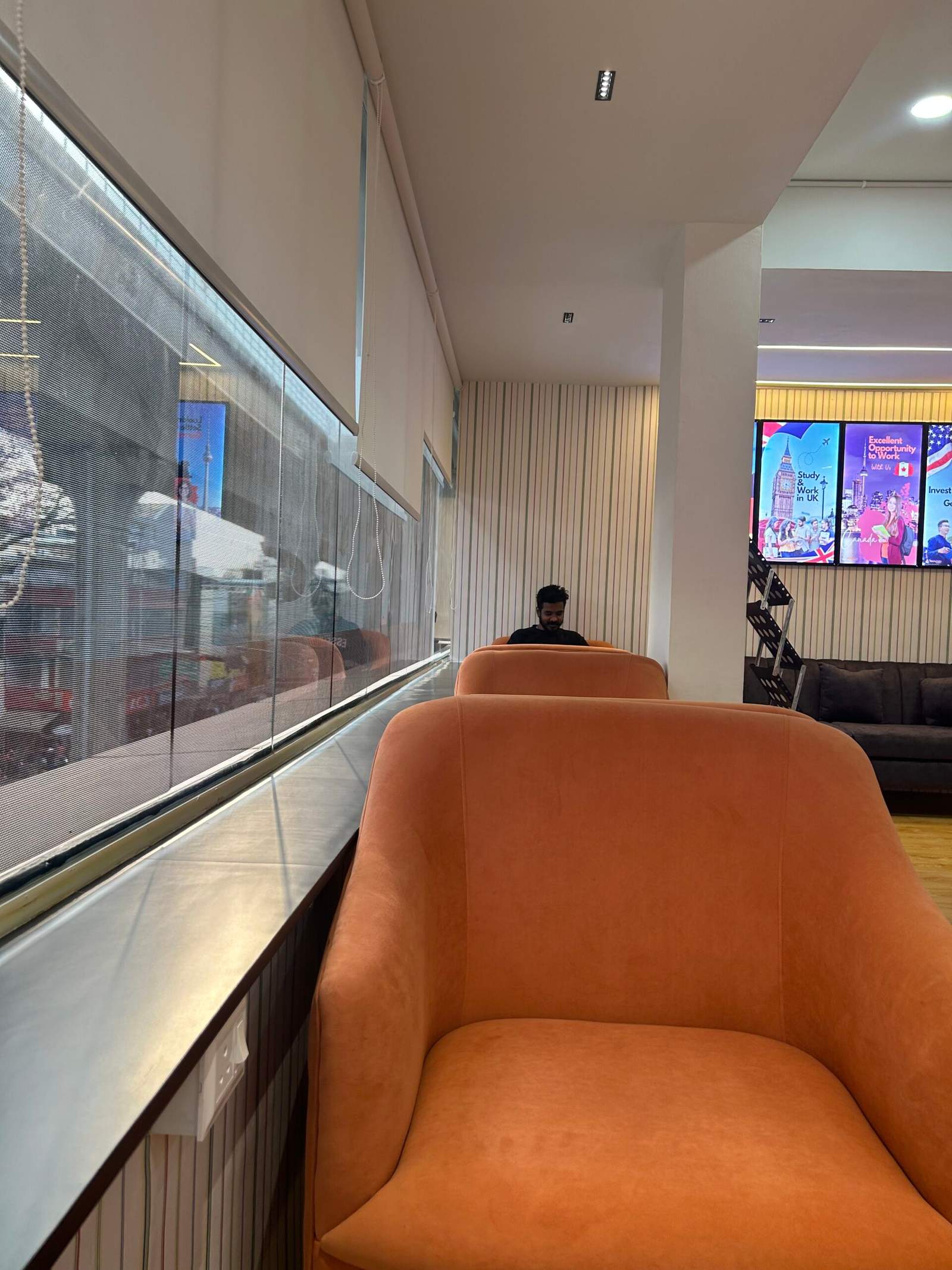 Contemporary office hall interior in Bangalore with sofa seating, wall photo frames, and warm lighting by Olangana Designs