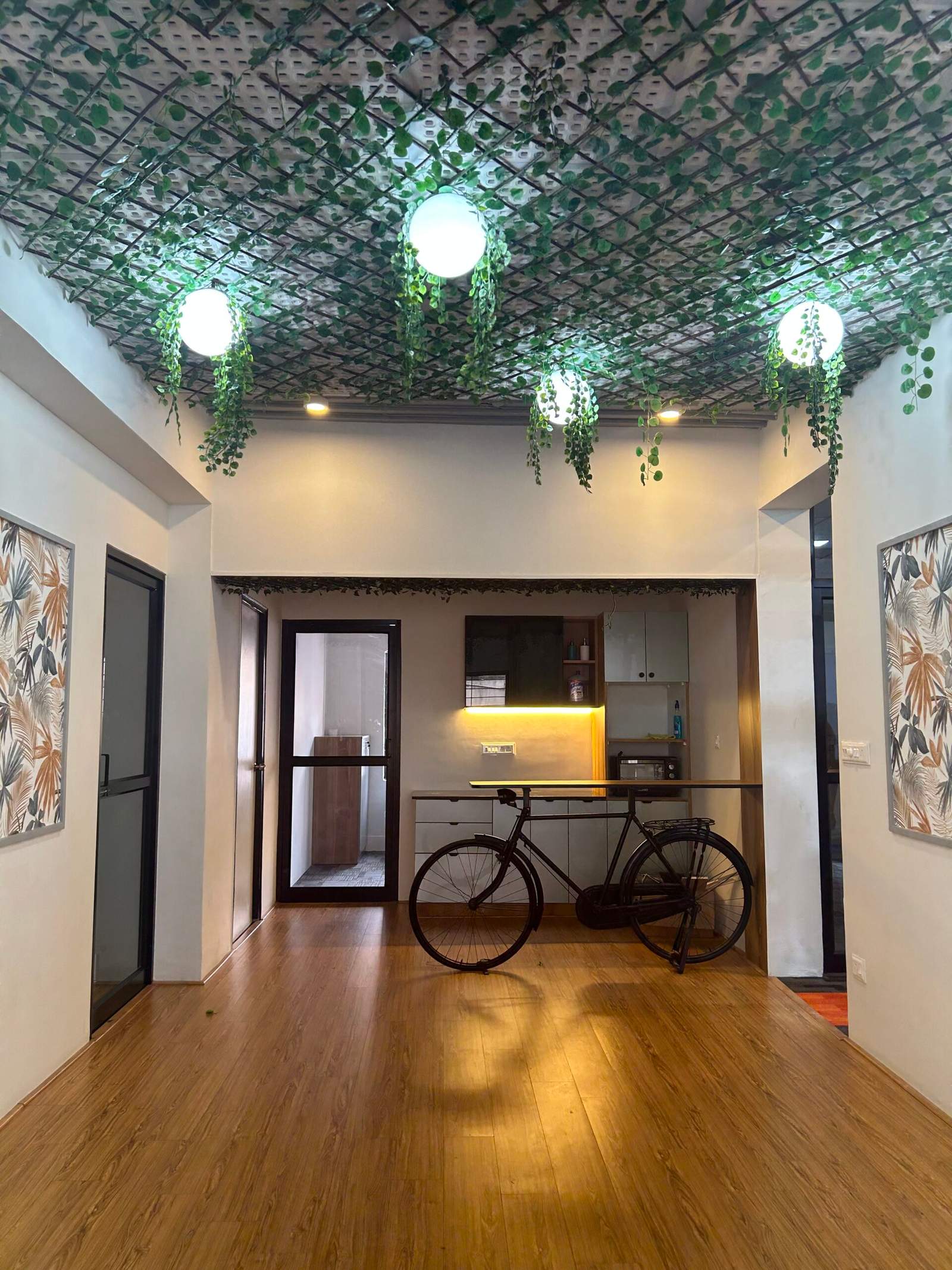 Minimalist office workspace in Bangalore with wooden floor, modern cabinet unit, and indoor décor by Olangana Designs